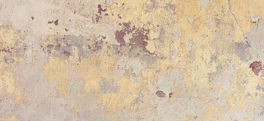 Old cracked weathered painted wall banner background texture. Yellow dirty peeled plaster wall with falling off flakes of paint