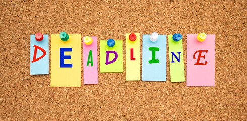 Multicolor notes with letters pinned on a cork notice board.