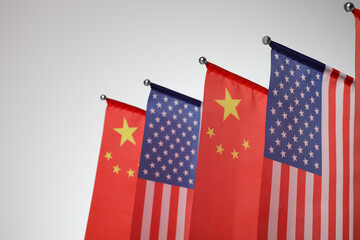 USA and China flags on light background, closeup. International relations