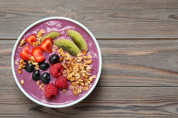 Delicious acai smoothie with fruits on grey wooden table, top view. Space for text
