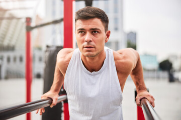 Fototapeta na wymiar Muscular man training with self weight outdoors