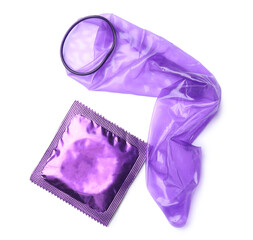 Unrolled violet condom and package on white background, top view. Safe sex
