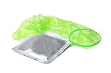 Unrolled green condom and package on white background. Safe sex