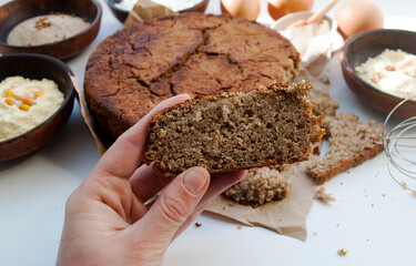 Various gluten-free flour. Round gluten free homemade bread. Buckwheat, chickpea, rice, corn flour, eggs and honey. healthy eating concept, flat lay. A piece of bread in a female hand.