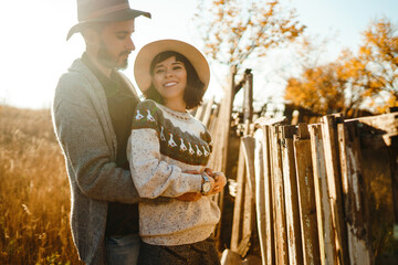 Stylish hipster couple outdoors on a beautiful autumn day in the park. Young couple in love  hugging and enjoying each other at sunset. The concept of youth, love and lifestyle.