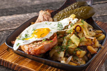 Fried pork meat with potatoes and egg.