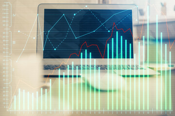 Double exposure of chart and financial info and work space with computer background. Concept of international online trading.