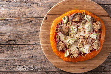 Autumn pumpkin pizza with vegetables on wooden table	
