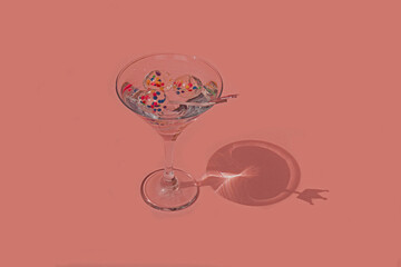 Copa de martini elegante sobre fondo rosa pastel