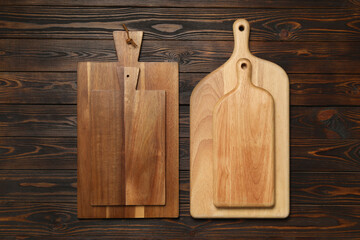 Set of wooden boards on brown table, flat lay. Cooking utensils
