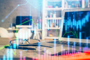 Financial graph colorful drawing and table with computer on background. Multi exposure. Concept of international markets.