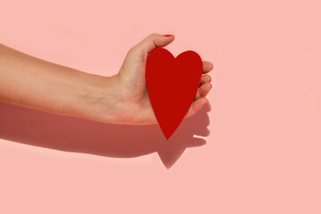 Mano humana sujetando un corazon con sus manos