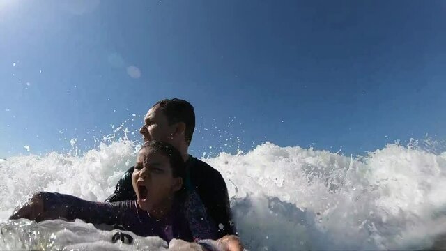 Father and his daughter having fun surfing together - Slow Motion