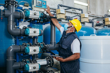 industry worker checking chemical water treatment equipment