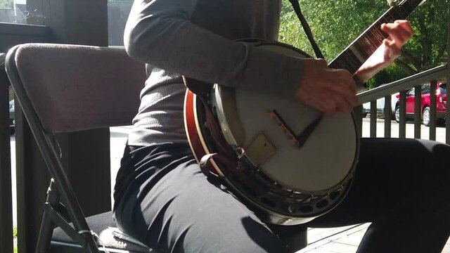 Slow motion of woman plucking a banjo