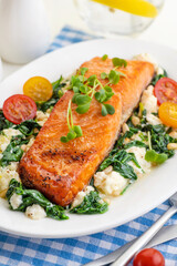 Grilled salmon steak with vegetables and fresh microgreens. Food concept for a ketogenic and no carbohydrate diet.