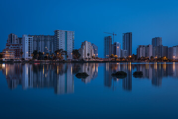 City skyline of Calpe reflected in the salt lake at dusk, Alicante, Spain