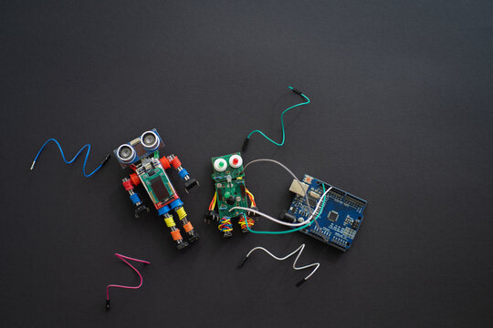 A metal robot and an electronic board that can be programmed. Robotics and electronics. DIY robotics. STEM and STEAM education for kids. Free space for text.