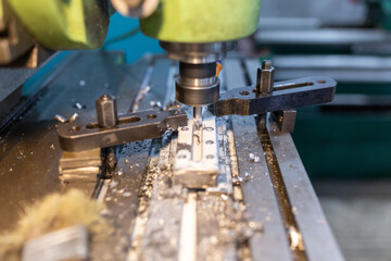 Execution of the work process on an industrial milling machine. The metal part is clamped in the...