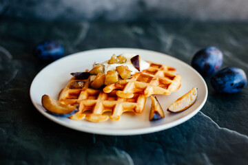Delicious Viennese waffles on a plate. Waffles with sour cream, honey and fruits