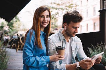 Couple using tablet and drinking coffee on terrace