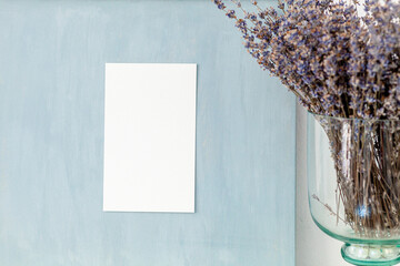 Vertical clean piece of paper on blue vintage painted board with lavender and tree cone