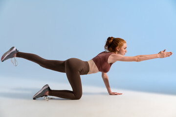 Fototapeta na wymiar Photo of athletic focused sportswoman doing exercise while working out