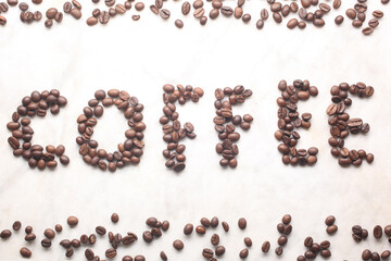 word coffe written with coffe beans on a marble table with copy space for your text