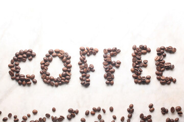 word coffe written with coffe beans on a marble table with copy space for your text