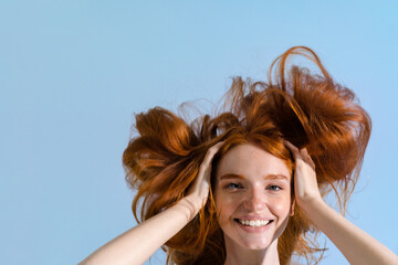 Photo of redhead smiling sportswoman making fun with her hair