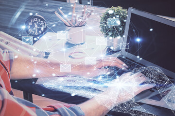 Envelop holograms with businessman working on computer on background. E-mail concept. Multi exposure.