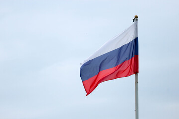Fototapeta na wymiar Waiving flag of Russian federation on cloudy sky background closeup