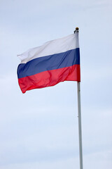 Waiving flag of Russian federation on cloudy sky background closeup