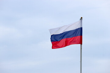 Fototapeta na wymiar Waiving flag of Russian federation on cloudy sky background closeup