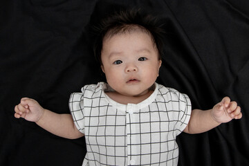 Portraiture image of Three month old Asian Cute little baby boy lsolated on Black