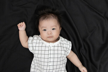 Portraiture image of Three month old Asian Cute little baby boy lsolated on Black