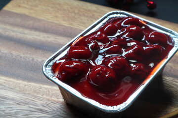 red berry cheese cakes are in the wooden tray on wooden black table in bakery shop during Christmas winter party with happy family members