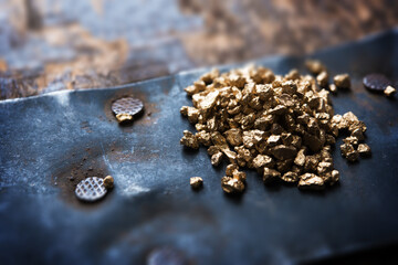 a mound of gold on a old wooden chest. Shallow depth of field.