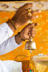 close up of the hand of a  balinese priest giving a blessing during a ceremony
