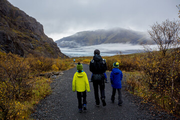 Father with children, walking on a path in beautiful nature of Skaftafell Glacier national park on a gorgeous autumn day in Iceland