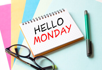The Notepad with the text Hello Monday is on colored paper with glasses and a pen