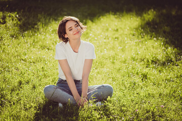 Photo of cute charming lady sitting lend ground fresh green grass enjoy sun rays eyes closed nature...