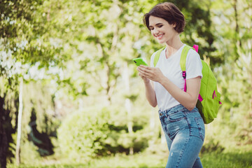 Profile photo of attractive cheerful lady influencer hold telephone school backpack on shoulders...