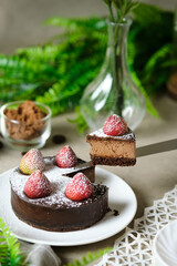 Mousse chocolate cake with strawberry and icing powder sugar. set on cafe table.