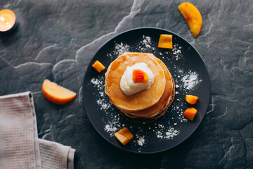 Pancakes with peaches, cream and honey. Pancakes on a plate. Tasty breakfast