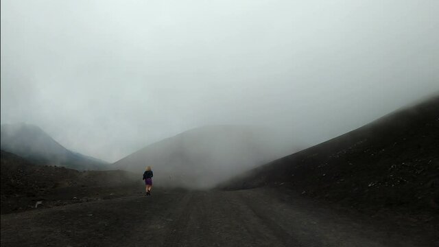 suggestive view of solitary walker on the slopes of Etna, sicily, august 2020