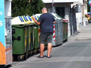 Ein Mensch  wirft was weg in den Mistkübel 