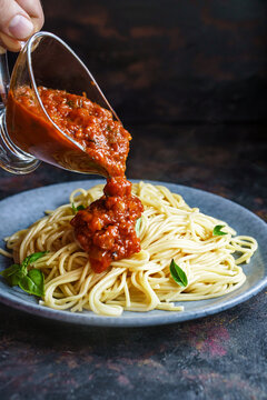 Pouring spaghetti with tomato sauce. Pasta al pomodoro