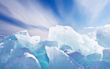 Lake Baikal in February. Large ice hummocks against a blue sky with stratus clouds on a sunny frosty day. Beautiful winter landscape. Natural cold background. Winter ice travel on the lake