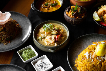 Sri lankan cuisine dishes on restaurant table on dark wooden background.